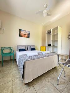 una camera con un grande letto e una sedia verde di Pousada Serrate a Ubatuba Altre 32 foto