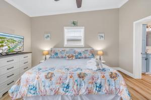 Un dormitorio con una cama y un televisor de pantalla plana. en Captain's Cove ~Waterfront Home with Pool & 75' Dock, en Marathon 37 fotos más