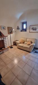 een woonkamer met een bank en een tv aan de muur bij La Piazzetta in Introdacqua