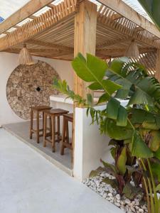 a patio with a table and chairs under a roof at Villa Jena 3 bedroom private pool in Nungwi