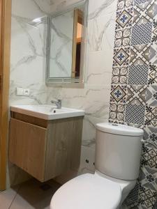 ein Badezimmer mit weißer Toilette und Waschbecken in der Unterkunft F2 Luxury & Light in Oulad Akkou + 12 Fotos