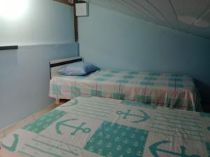 Un dormitorio con dos camas y una alfombra en el suelo. en Hostel & Cia Itanhaém, en Itanhaém