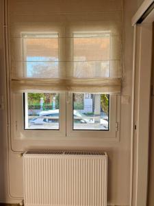 a window with a radiator and a window blind at Eftychia's House in Marioláta +25 photos