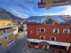 a red building with solar panels on top of it at La Tgoma - Hotel & Restaurant in Lenz
