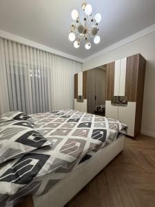 ein Schlafzimmer mit einem großen Bett und einem Kronleuchter in der Unterkunft Luxury Penthouse in Ferizaj