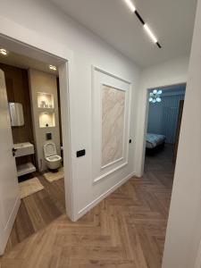 ein Badezimmer mit einer Tür, die zu einer Toilette führt in der Unterkunft Luxury Penthouse in Ferizaj