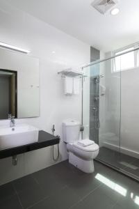 a bathroom with a toilet and a sink and a shower at One Pacific Hotel and Serviced Apartments in George Town