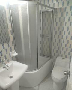 a bathroom with a shower and a toilet and a sink at Colibri Hostel in Armenia +5 photos