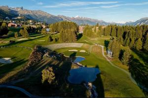 an aerial view of a golf course in the mountains at Sorecrans in Crans-Montana