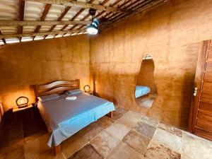 een slaapkamer met een bed en een spiegel aan de muur bij Bio-Resort Camping in Trairi