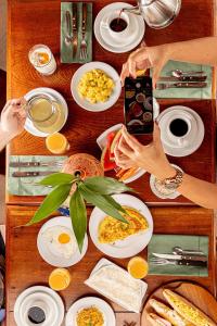 a person taking a picture of a table of food at Hotel Ilha do Marajó by Unna in Soure