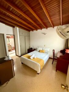 a bedroom with a bed and a chair in it at Hotel Balcones De Malibu in Medellín