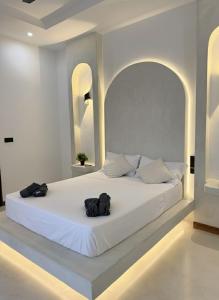 ein großes weißes Bett mit zwei schwarzen Säcken darauf in der Unterkunft 3 bedroom villa with private pool in Nungwi