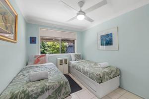 ein Schlafzimmer mit zwei Betten und einem Fenster in der Unterkunft Periwinkle Blue - Pet Friendly, Golden Beach in Golden Beach