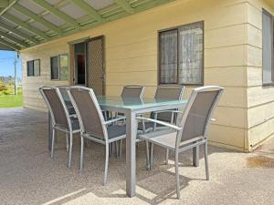 een tafel en stoelen op een terras bij 3 Barragoot Street in Bermagui