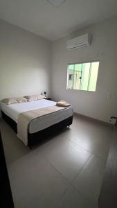 a bedroom with a bed and a window at Casa aconchegante com 02 quartos climatizados in Nova Mutum