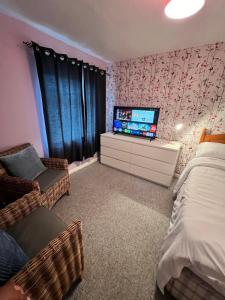 a bedroom with a bed and a tv on a dresser at Mona in Hull