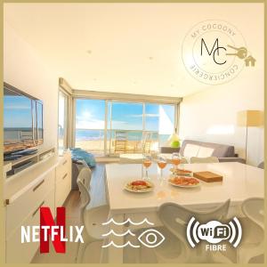 een woonkamer met een tafel met twee glazen wijn bij Douce escale - T3 d exception face mer in Saint-Jean-de-Monts