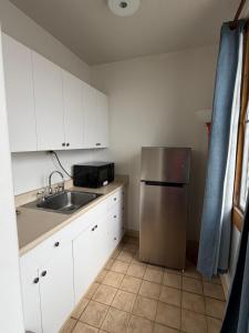 a kitchen with white cabinets and a stainless steel refrigerator at Central YMCA Residences in Honolulu
