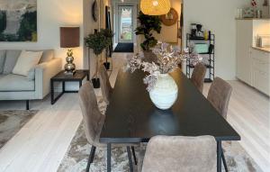 ein Esstisch mit einer Vase mit Blumen darauf in der Unterkunft Beautiful Home In Dronningmølle With Wifi in Hulerød