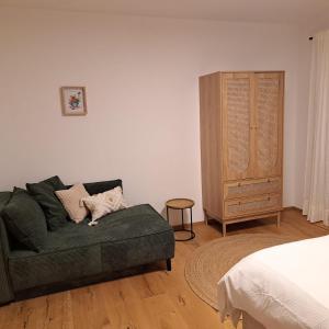 ein Wohnzimmer mit einer grünen Couch und einer Kommode in der Unterkunft Jägerchalet in Uttendorf