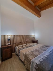 ein Schlafzimmer mit großem Bett und Holzdecke in der Unterkunft M&M apartments in Monclassico