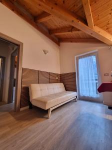 ein weißes Sofa in einem Zimmer mit einem großen Fenster in der Unterkunft M&M apartments in Monclassico