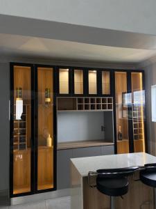 a kitchen with wooden cabinets and a counter with stools at Khulanathi Guesthouse in Engcobo