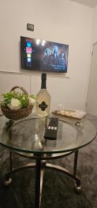 een glazen tafel met een fles en een afstandsbediening erop. bij Comfy 2 Bedroom House near City Centre and Uclan in Preston