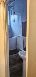 een witte badkamer met een wastafel en een bad bij Comfy 2 Bedroom House near City Centre and Uclan in Preston +26 foto's