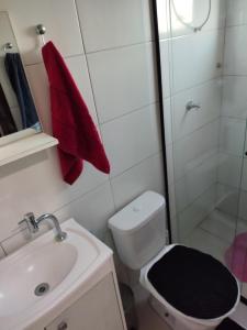 a bathroom with a toilet and a sink and a shower at Loft Praia da Vila in Imbituba