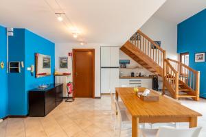 een eetkamer met blauwe muren en een houten tafel bij Balcone di Noa e Stella in Menaggio