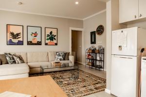 a living room with a couch and a refrigerator at Kiama Tea House in Bicheno