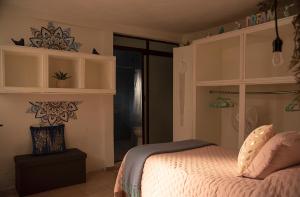 a bedroom with a bed with pink sheets and a window at Xochi Calli in Nogales