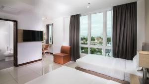 una habitación de hotel con una cama y una ventana grande en One Pacific Hotel and Serviced Apartments, en George Town