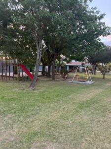 a park with a playground with a slide and trees at Casa quinta in La Banda