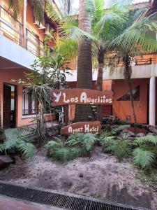 een bord voor een gebouw met palmbomen bij Apart Hotel Los Angelitos in Federación