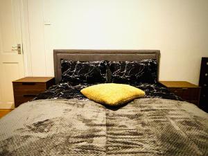 een bed met een geel kussen erop bij Midnight Horizon in Ponders End