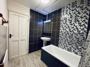 een badkamer met een bad, een toilet en een wastafel bij Midnight Horizon in Ponders End +2 foto's