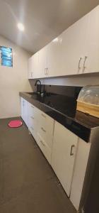 una cucina con armadi bianchi e un tappeto rosso sul pavimento di Welcome Home - VCDU Riverview  Altre 2 foto