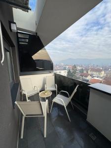 a balcony with chairs and a table and a view at Cozy apartment Banja Luka in Budžak