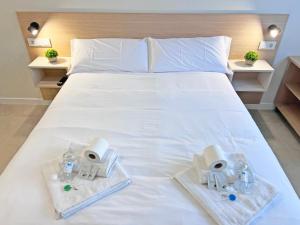 a bedroom with a white bed with two towels and glasses at NUEVO -Bogotá Suites- Apartamentos con cocina, AC, 15min del centro a pie in Alicante +136 photos