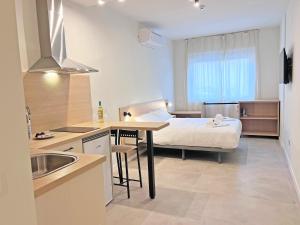 a kitchen and a bedroom with a bed in a room at NUEVO -Bogotá Suites- Apartamentos con cocina, AC, 15min del centro a pie in Alicante