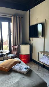 una camera con letto, TV e sedia di CASA CONCEITO - studio panoramico, suites e quartos a São José