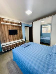 a bedroom with a bed and a tv and a mirror at Residencial Nicole in Florianópolis