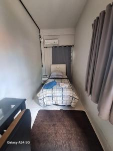 una piccola camera con un letto in una piccola stanza di CASA CONCEITO - studio panoramico, suites e quartos a São José
