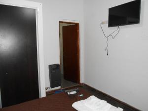 een kamer met een bed en een televisie aan de muur bij Apart Hotel Los Angelitos in Federación