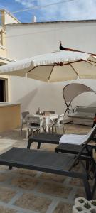 a patio with two chairs and an umbrella at Romantica in Brindisi