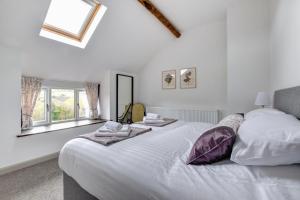 een slaapkamer met een groot wit bed met handdoeken erop bij 2 Bed in Machynlleth oc-bow39 in Darowen