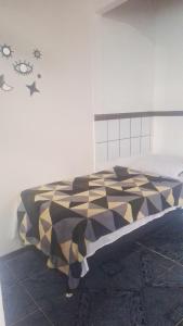 a bed with a black and white comforter in a room at Panga Loft in Abraão